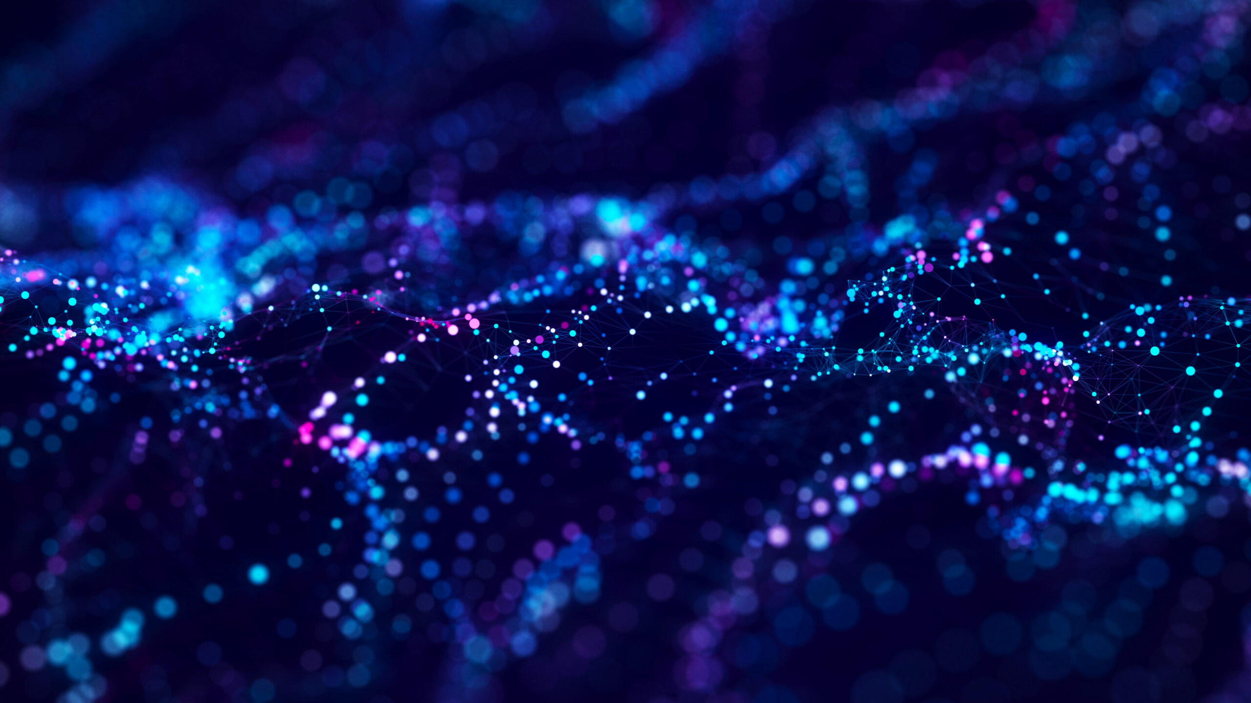 Abstract digital network wave made of glowing blue, cyan, and purple particles with connected lines on a dark background.